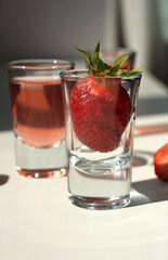 strawberry compote tincture with ice in glass glasses with strawberries and ice cubes