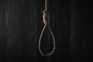 Tied rope noose against dark wooden background