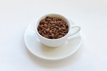 Coffee beans in a white mug on the table