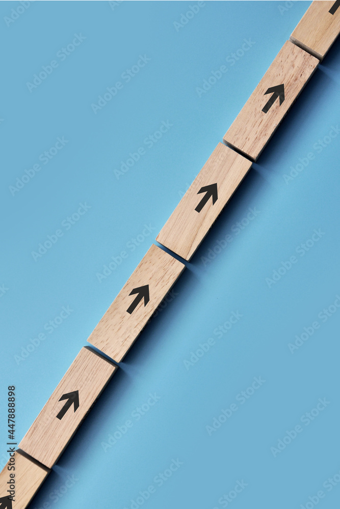 Poster wooden cubes with drawings of up arrows on them. a symbol of development and moving forward in life
