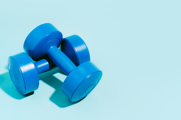blue dumbbells on blue background. Sport and exercise. 3d illustration