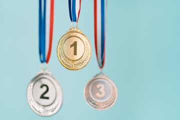 three medals (gold,silver,bronze) on blue background.concept of award and victory.copy space