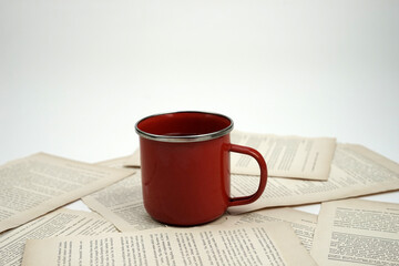 A cup of coffee with vintage book papers. 