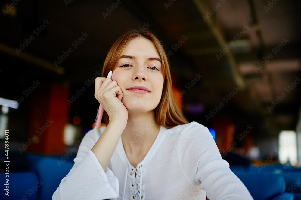 Aufkleber portrait of intelligent female student with pen looking at camera while learning and studying in uni