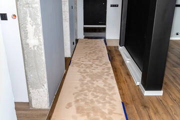 Modern vinyl panels imitating wood in the living room, covered with corrugated cardboard to protect...
