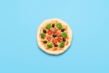 Vegetarian pizza uncooked on blue table. Raw vegan pizza, flat lay