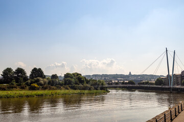 Fototapeta premium River Lune in Lancaster, UK with cable-stayed the Millennium Bridge in a background.