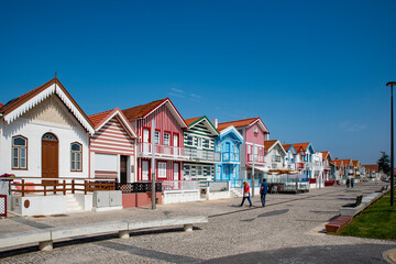 Street with colorful striped houses typical of Costa Nova, Aveiro, Portugal.