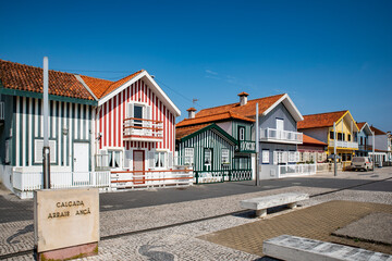 Street with colorful striped houses typical of Costa Nova, Aveiro, Portugal.
