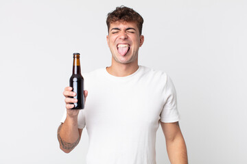 young handsome man with cheerful and rebellious attitude, joking and sticking tongue out and...