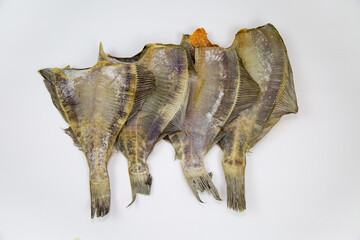 Flounder (Latin Pleuronectes platessa) dried without a head folded in a row isolated on a white background. Food is a delicacy snack for beer.