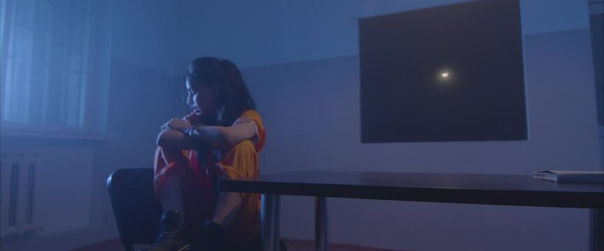 crazy girl  in the interrogation room in handcuffs