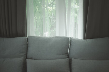 Sofa with open window curtains transparent curtain in room.
