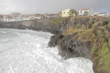 Gloomy sky over the sea and coastal buildings on a cold windy day