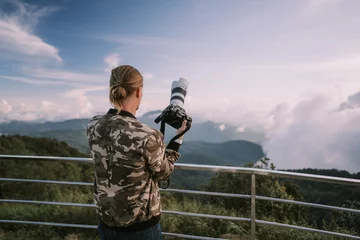 Tuinposter Man photographer shooting sunset at the highest point in Thailand © Natalia