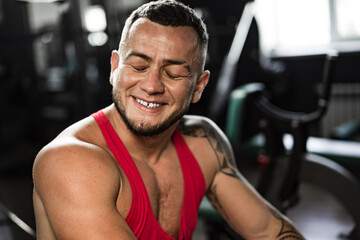 Portrait of man bodybuilder in red shirt in gym