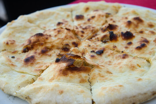 Traditional Croatian rustic bread - close up of a flatbread pita with salt, garlic and olive oil
