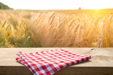 wooden board table in front of wheat field on sunset light. Ready for product display montages
