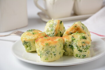 Healthy snack Broccoli muffins with cheddar cheese and thyme close-up on the table.