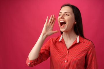 Portrait of young woman shouting over pink background