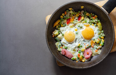 Brunch-fried eggs with vegetables in a frying pan