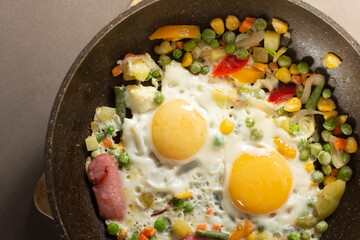 Brunch-fried eggs with vegetables in a frying pan
