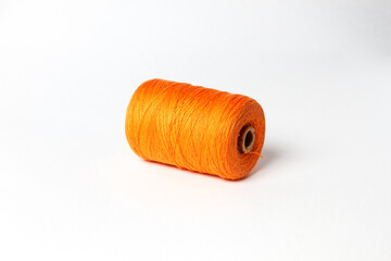 A spool of orange thread. White background.