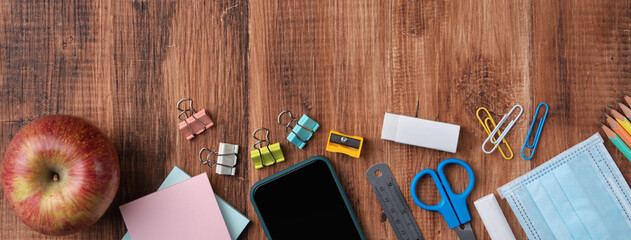 Back to school design concept with stationery over wooden table background.