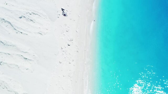 Drone raising shot of beautiful scenic beach with white sand and turquoise blue sea water, summer holiday in Greece, Egremni beach of Lefkada island.