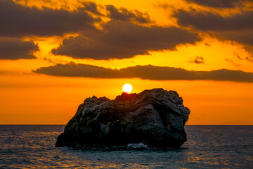 Fototapeta na wymiar Coastal Rock and Bright Sea Sunset Colours