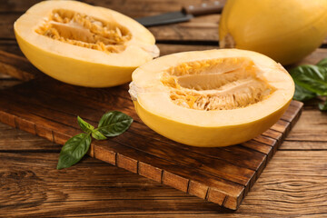 Halves of fresh spaghetti squash on wooden table. Cooking vegetarian dish