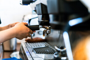 Close-up hand of barista plug the portafilter into coffee machine to make espresso