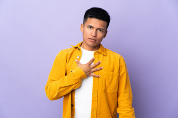 Young Ecuadorian man isolated on purple background surprised and shocked while looking right