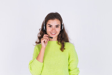 Young beautiful woman with freckles light makeup in sweater on white background with headphones helpline worker call centre manager happy smile