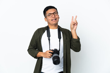 Naklejka premium Young Ecuadorian photographer isolated on white background smiling and showing victory sign