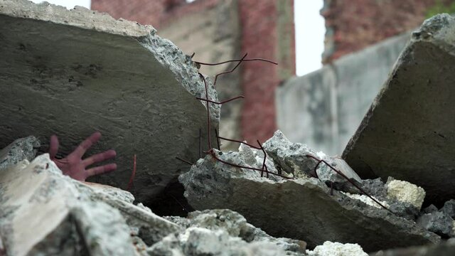 Hand of a man who crashed a house. Pressed by a reinforced concrete slab during an earthquake or explosion