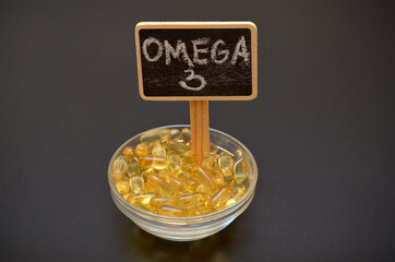 fish oil capsules in a bowl and omega 3 lettering