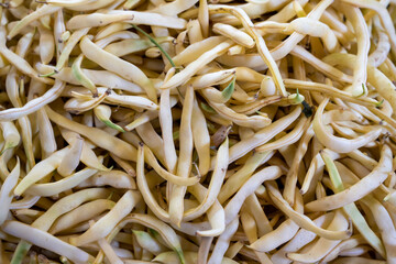 photo of a market stall with fresh vegetables, produce displayed for sale, white beans