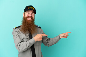 Redhead security man isolated on white background pointing finger to the side and presenting a product