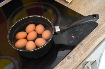 Oeufs dans une casserole d'eau sur une table de cuisson