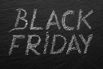 black friday written with chalk on a black stone tile, macro texture