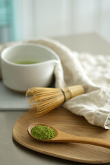 Mixing matcha with wooden spoon and chasen whisk in chawan bowl.