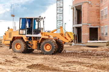 A forklift at a construction site is lifting a reinforced concrete slab. Construction machine. Industry. Construction machinery for moving goods.