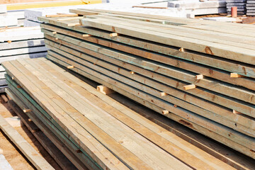 Storage of boards and building materials at the construction site. Preparation of material for building a house.
