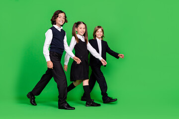 Full size profile photo of nice little girl boys go wear school uniform isolated on green background