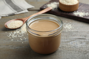 Jar of tasty sesame paste on wooden table