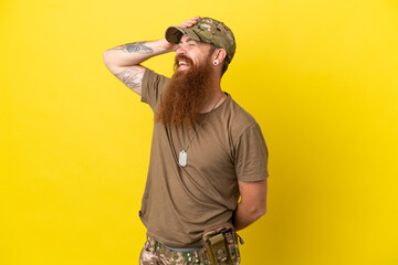 Redhead Military man with dog tag isolated on yellow background has realized something and...