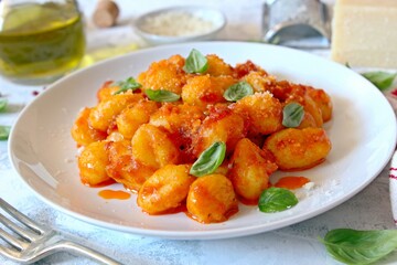 Traditional Italian potato gnocchi with tomato sauce, parmesan cheese and fresh basil. Top view.