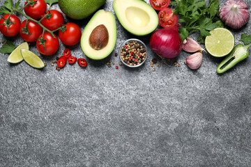 Fresh guacamole ingredients on grey table, flat lay. Space for text