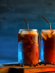 cold brew cold coffee in tall glasses with cream and roasted coffee beans. neon style backlight...